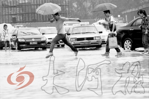 鄭州經(jīng)三路與北環(huán)交叉口處，積水較深，行人們不得不“練輕功”。 記者 白周峰 攝影