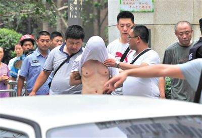 昨日，成都警方抓捕時與毒犯發(fā)生槍戰(zhàn)。一名男犯罪嫌疑人被警方押出。
