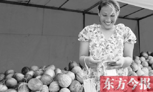 昨日，開封瓜農史瑩瑩幸福地數著賣瓜錢