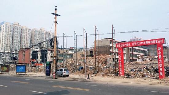 015年5月31日，在社區(qū)干部的帶頭拆遷下，親賢社區(qū)的“城中村改造”拉開(kāi)帷幕。由于前期“清產(chǎn)核資”及補(bǔ)償標(biāo)準(zhǔn)等因素，拆遷改造工作推進(jìn)并不順利。圖為位于體育西路東側(cè)集體所有的商鋪率先被拆遷完畢，用于遮擋的圍擋正在施工中。（拍攝：2015年9月16日）