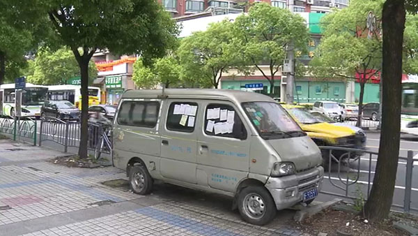 被棄置在人行道上的面包車(chē)。
