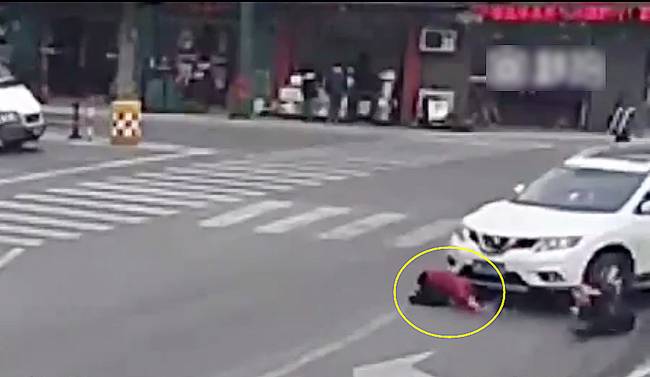 圖為小姑娘被卷進(jìn)車輪下瞬間。