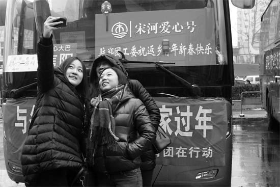 昨天上午8時(shí)，鄭州正道中環(huán)百貨廣場(chǎng)，準(zhǔn)備回家的老鄉(xiāng)在愛心大巴車前合影留念
