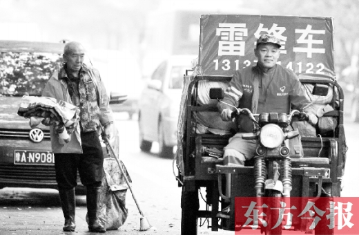 鄭州市商城路，一名環(huán)衛(wèi)工懷抱著剛剛收到的毯子，目送“雷鋒哥”孫德坤離開