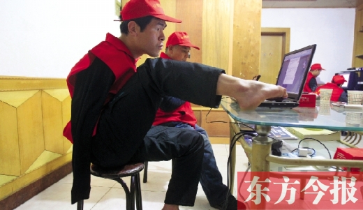 12月2日，一名“豫殘聯(lián)盟”志愿者正通過網絡、微博等聯(lián)絡著各地殘疾人朋友 東方今報首席記者 張曉冬