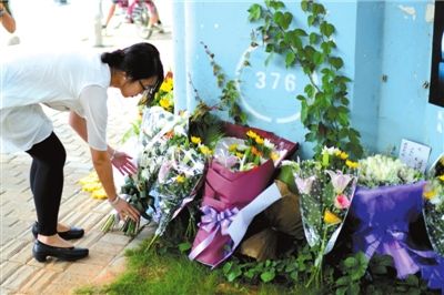 6月8日下午，記者來到廈門公交車爆炸事發(fā)現(xiàn)場橋下，附近已聚集了十幾個自發(fā)前來悼念的市民。橋墩下排放了一圈或黃或白的菊花，還有玖瑰、百合等。
