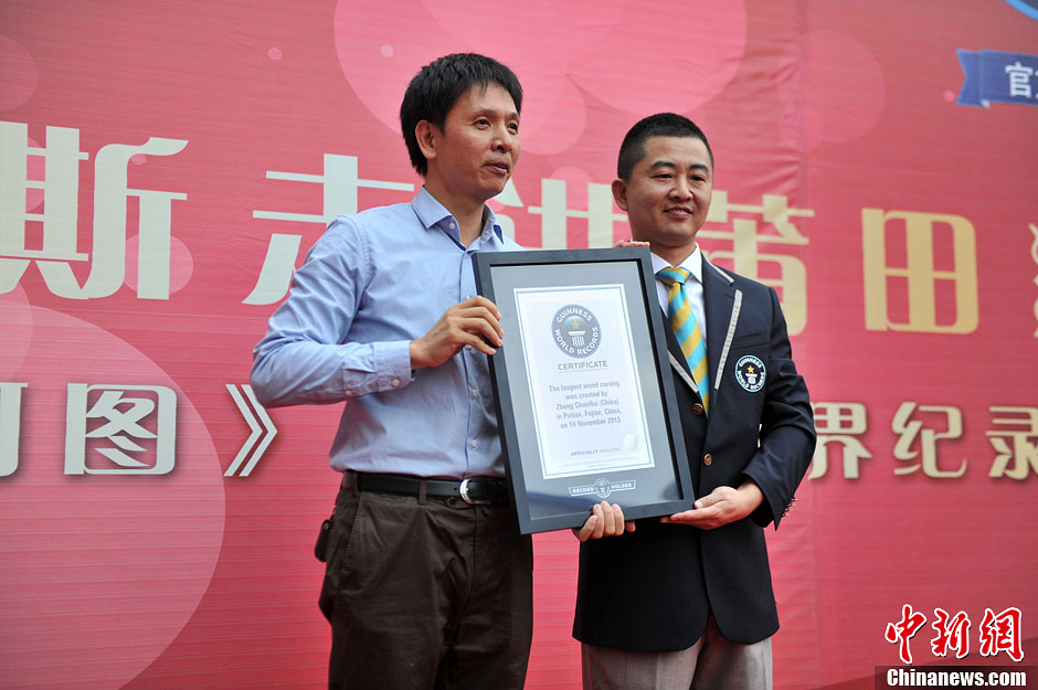 圖為世界吉尼斯認證官為鄭春輝（左）頒發(fā)證書。呂明 攝