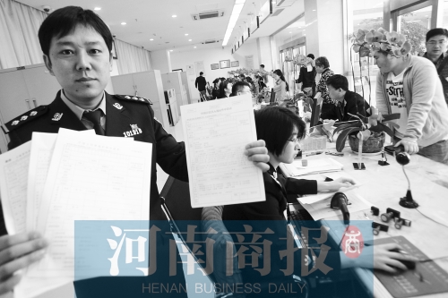 　民警左手拿的是新申請表，右手拿的是三份老申請表 王春勝/攝