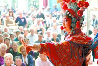 圖為8月15日戲曲演員在“流動(dòng)舞臺(tái)車”上表演傳統(tǒng)地方戲《穆桂英下山》。