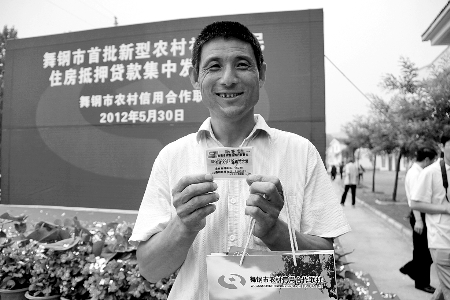領(lǐng)到貸款，農(nóng)民開(kāi)心地笑了。
