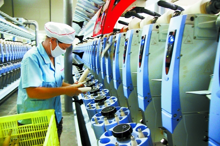 7月3日，在鄧州市永泰棉紡有限公司電腦控制全自動紡紗車間，紡織工人正在生產(chǎn)棉紗。