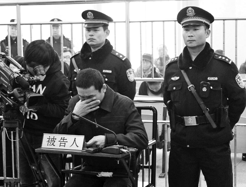 庭審中,29歲的李軍低著頭。