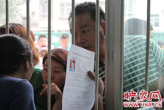 不少家長擠在報名窗口前咨詢報名事宜。