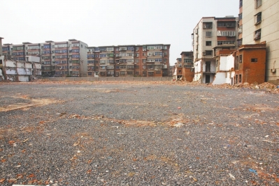為降塵，旮旯王村拆遷后裸露的地面上鋪了一層石子。