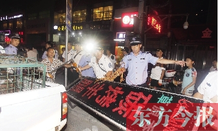 7月8日晚，鄭州市商城路一家占道經(jīng)營的攤販招牌被執(zhí)法隊(duì)員“登記保存”