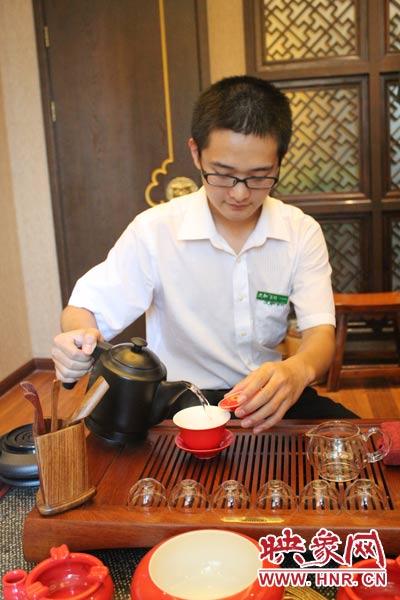 1、水壺里的水煮沸，李克勤把茶葉放進茶荷里，準(zhǔn)備溫杯沖茶