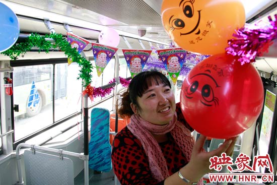 鄭州快速公交B3區(qū)間線車長李鵬云在車廂里懸掛氣球，布置圣誕車廂，營造歡樂圣誕氛圍