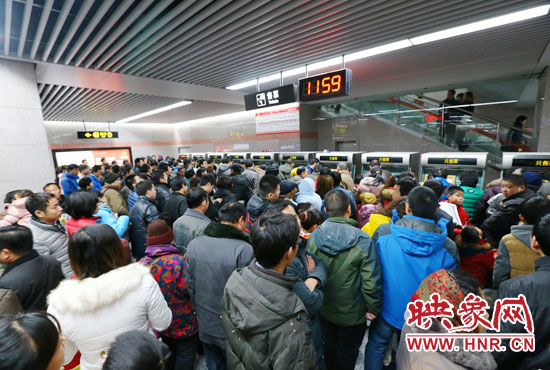 地鐵開通首日，上午十一點五十九分，紫荊山地鐵站售票機(jī)前擠滿了買票的市民。