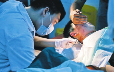 孩子身上有7道傷痕，其中兩道需要縫合，其他的均為擦傷，醫(yī)生正對(duì)他施治。