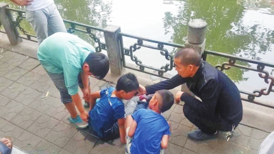 男孩被救出后，圍觀群眾幫他控水換衣服。