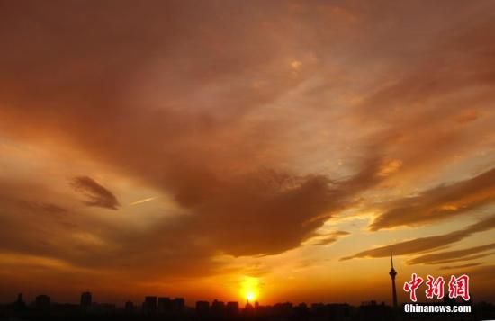12月8日下午，強(qiáng)烈的西北風(fēng)光臨北京，吹散了籠罩全城上空的霧霾，冬日罕見(jiàn)的艷麗晚霞映紅了半邊天。