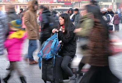 春運(yùn)首日，北京站客流量明顯增多，一名女孩在人流中等待進(jìn)站。