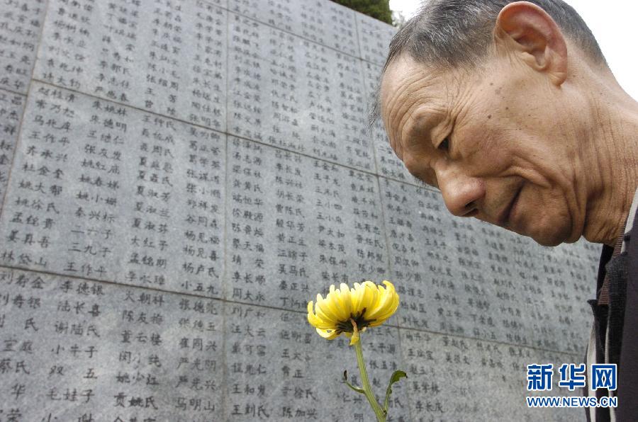 2006年4月5日，74歲的南京大屠殺幸存者佘子清手捧鮮花，祭奠被日軍殺害的母親。