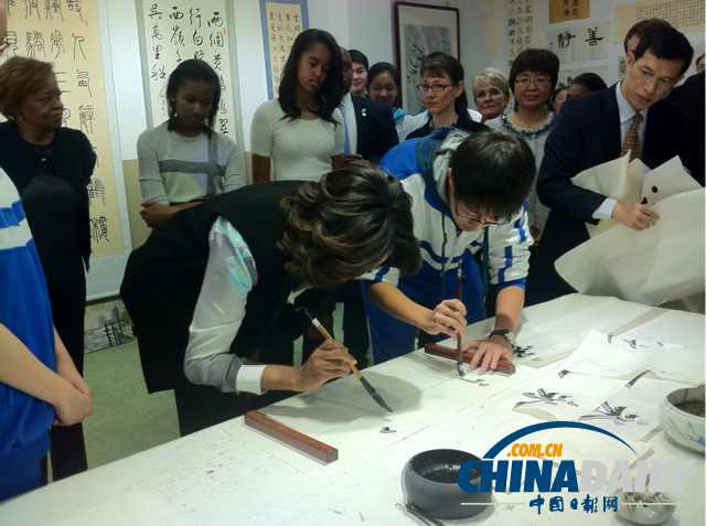 　北京時(shí)間3月21日，美國第一夫人米歇爾參觀北師大二附中時(shí)，與學(xué)生一起練習(xí)書法。