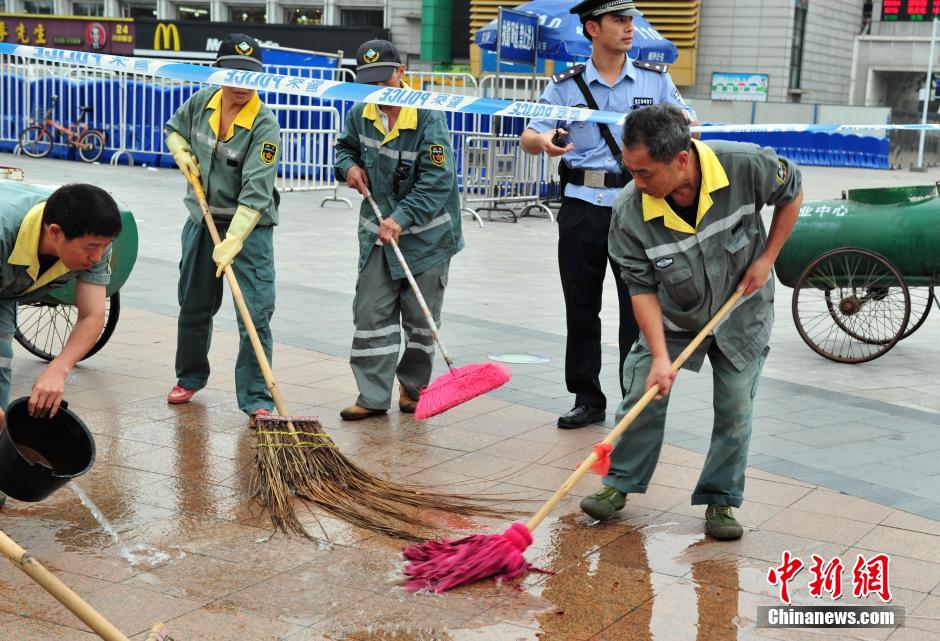 圖為環(huán)衛(wèi)工人在清理案發(fā)地點的血跡。