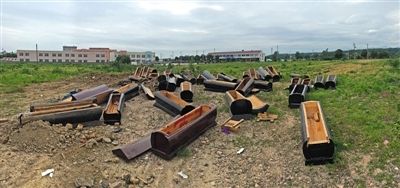 40多副棺木被砸壞后，扔在荒地上。