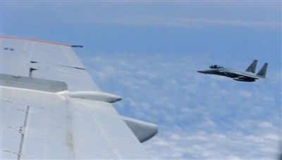 國防部網(wǎng)站12日公布的視頻截圖,日本F-15軍機從中國圖-154機頭方向危險切入,兩者最近距離約30米左右。