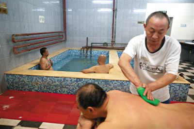 客人在搓澡。近日，百年歷史的鑫園浴池宣布將關(guān)張。新京報記者