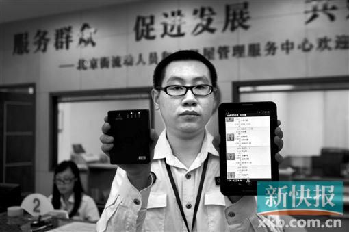 　越秀區(qū)北京街出租屋外來(lái)暫住人員管理服務(wù)中心的工作人員展示到出租屋登記來(lái)穗人員信息的儀器。