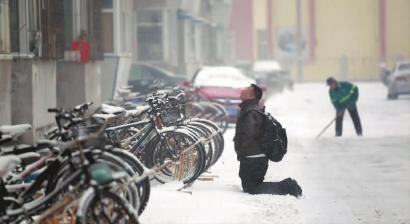 小伙子跪在樓前，一直抬頭看著樓上。 孫立國(guó)/攝