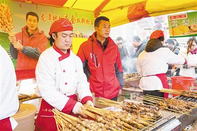 賣(mài)羊肉串?dāng)偽焕习遐w山（穿紅衣者）。新京報(bào)記者