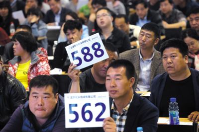昨日，拍賣現(xiàn)場競拍者舉牌競拍。新京報記者