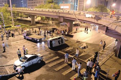 路虎沖下國貿(mào)橋砸中一輛起亞轎車，橋上厚達幾十厘米的水泥護欄被撞斷，碎石四處散落，數(shù)十群眾在現(xiàn)場圍觀。