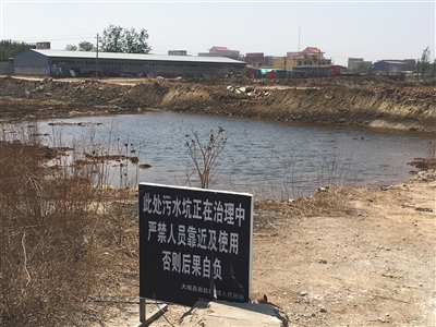 化肥廠滲坑的三分之一經過治理，但水質仍然呈黃褐色。