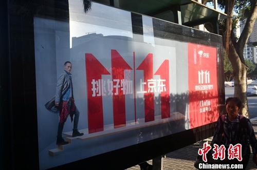 資料圖：11月1日，福州民眾從雙十一廣告牌前經(jīng)過。中新社記者 呂明 攝