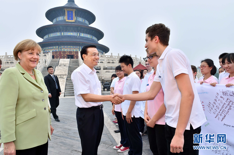 李克強同默克爾與青少年代表親切交流。