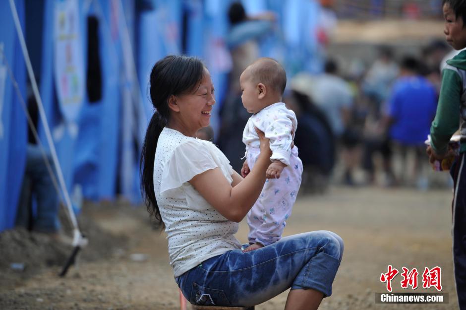 8月6日，一名年輕的母親在和孩子玩樂。