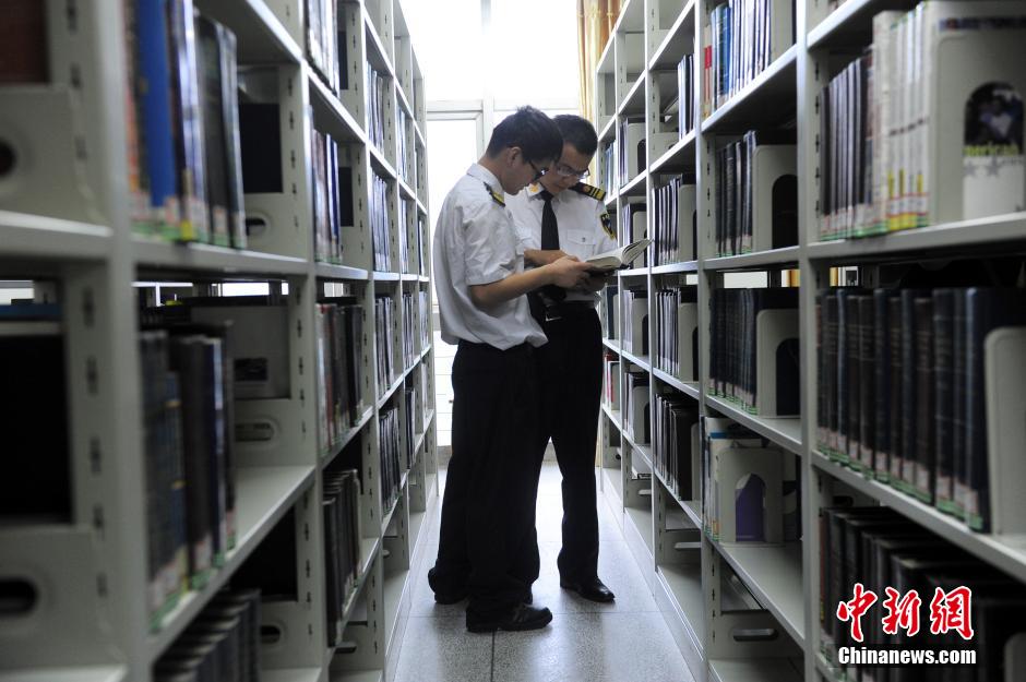 5月8日，武漢輕工大學(xué)保安吳濤與江力在圖書館交流學(xué)習(xí)。中新社發(fā) 張暢 攝
