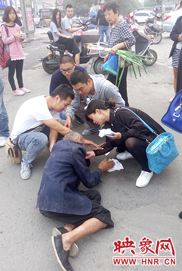 一些愛(ài)心市民在撥打了110和120后，上前給老人擦臉上的血跡。