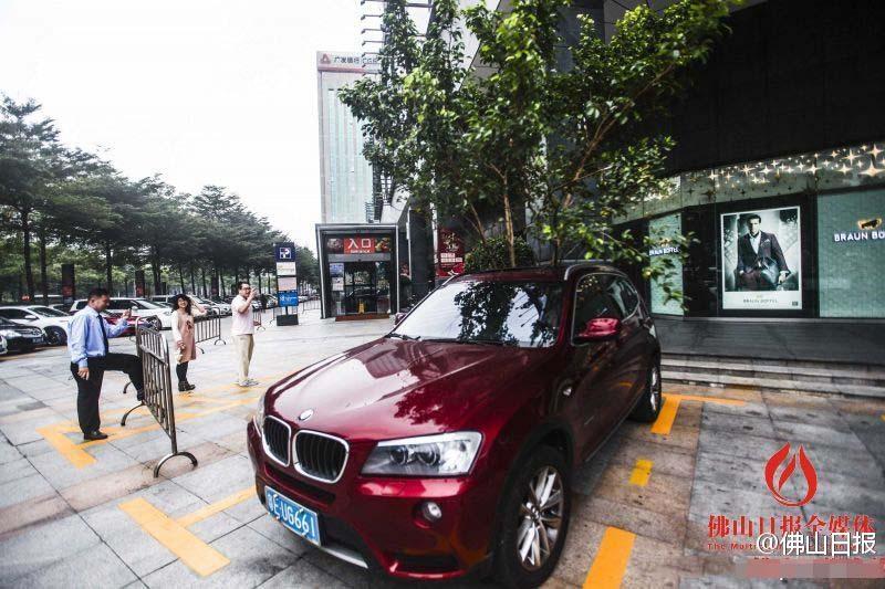 一輛停在停車位上的寶馬轎車，被墜落的樹枝砸中，樹枝徑直插入車內，現(xiàn)場引發(fā)不少市民圍觀拍照。