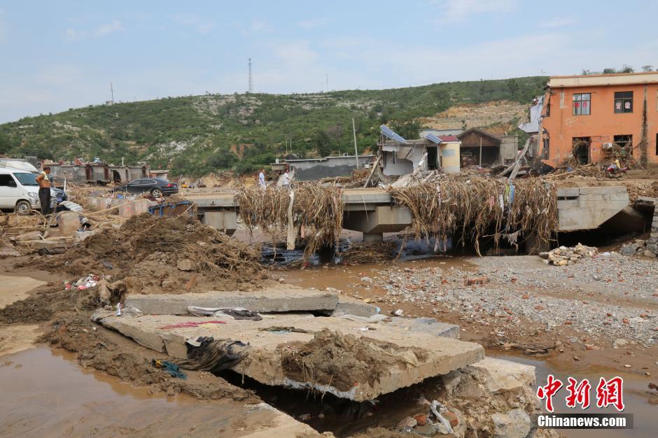 圖為洪水過后，坍塌的橋梁上遺落大量雜草。