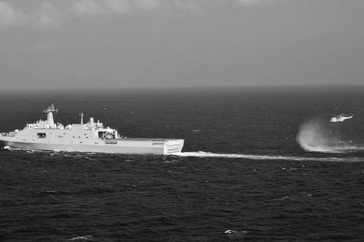 11日，抵達馬航飛機失聯(lián)海區(qū)的海軍井岡山艦與艦載直升機協(xié)同展開立體搜救行動。新華社發(fā)
