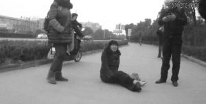 鄭大姐坐在地上，警方趕到進(jìn)行施救。（視頻截圖由警方提供）