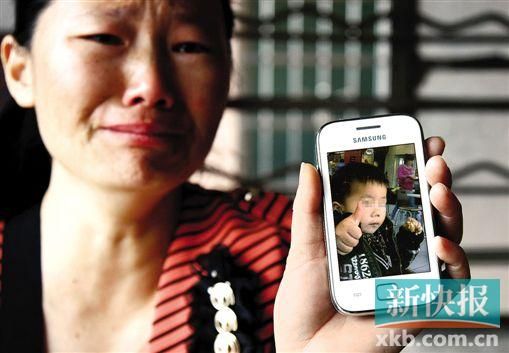 男童的舅媽拿著小益的照片,悲痛欲絕。 新快報記者 畢志毅 攝