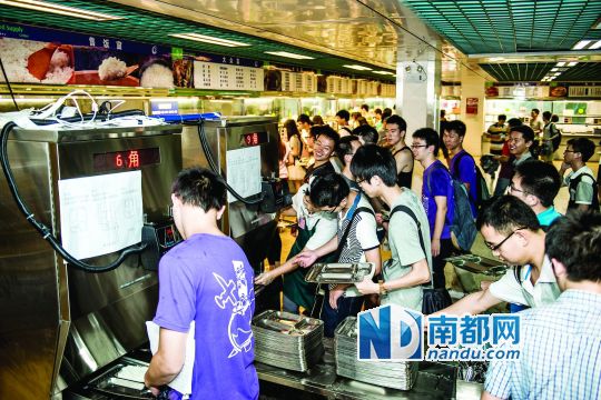 昨日，華南理工大學(xué)一食堂內(nèi)，學(xué)生們正在使用新安裝的自動打飯機(jī)打飯。中新社發(fā)