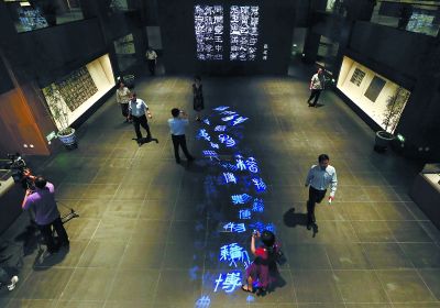 昨天，在國(guó)家典籍博物館內(nèi)，通過(guò)藝術(shù)投影技術(shù)呈現(xiàn)在展廳地面上的“漢字歷史長(zhǎng)河”，引得參觀者駐足觀看。
